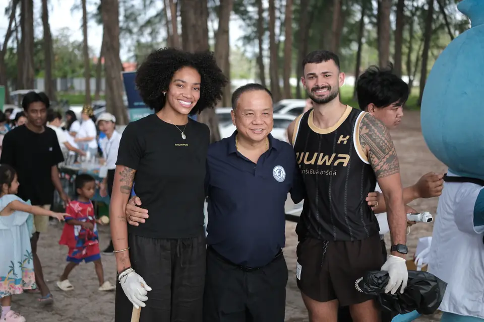 Two Khunpon crew members with a guest at the beach clean-up