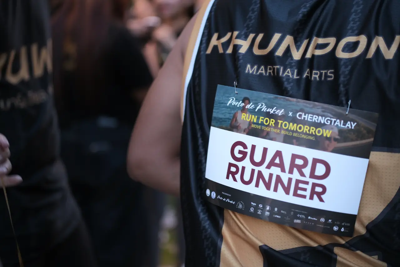 A Khunpon crew member wearing a Run for Tomorrow race bib marked Guard Runner