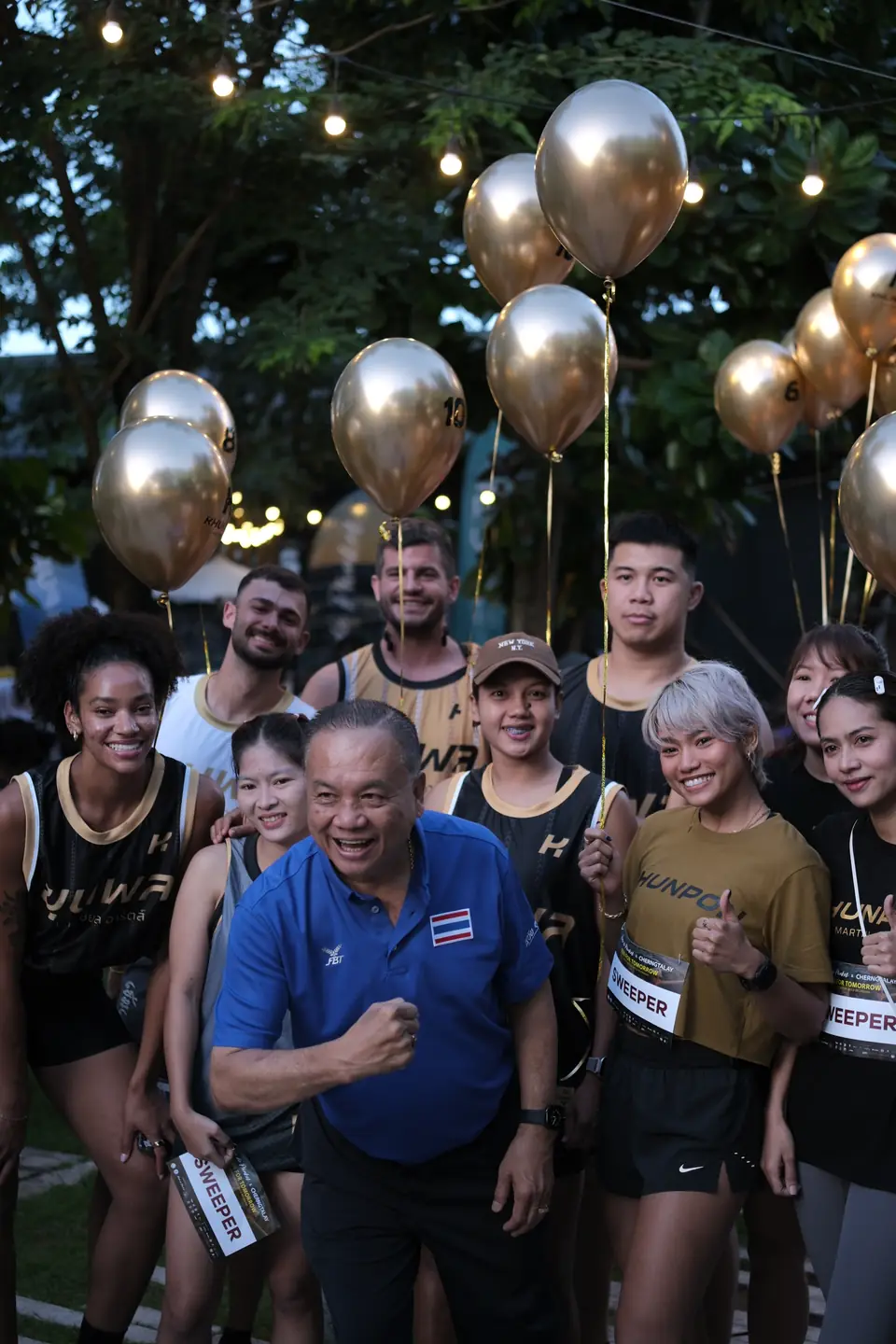 Khunpon's crew and a guest with gold balloons at the start area