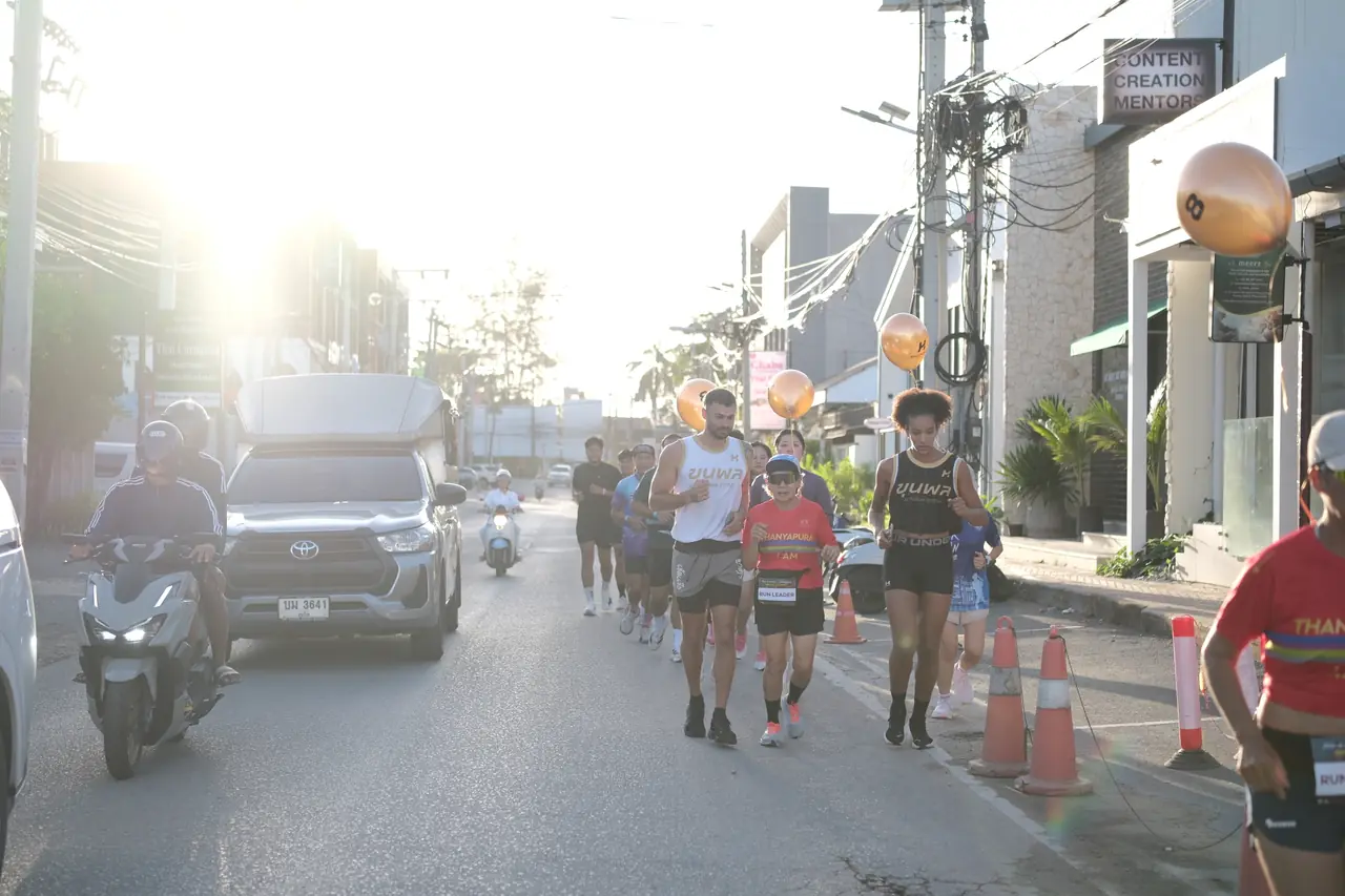 Runners on a road in Cherngtalay, with gold balloons along the route