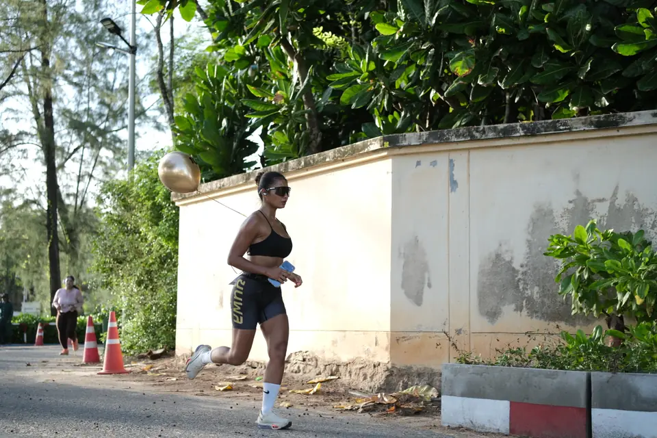 A Khunpon runner on the 5K route past a white wall