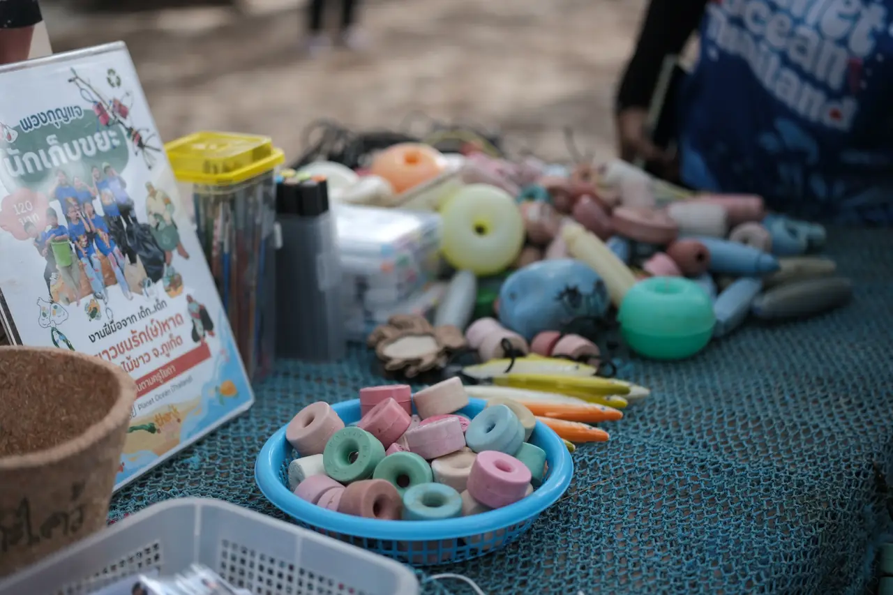Colourful rings and small objects made from recycled plastic on a table at the clean-up