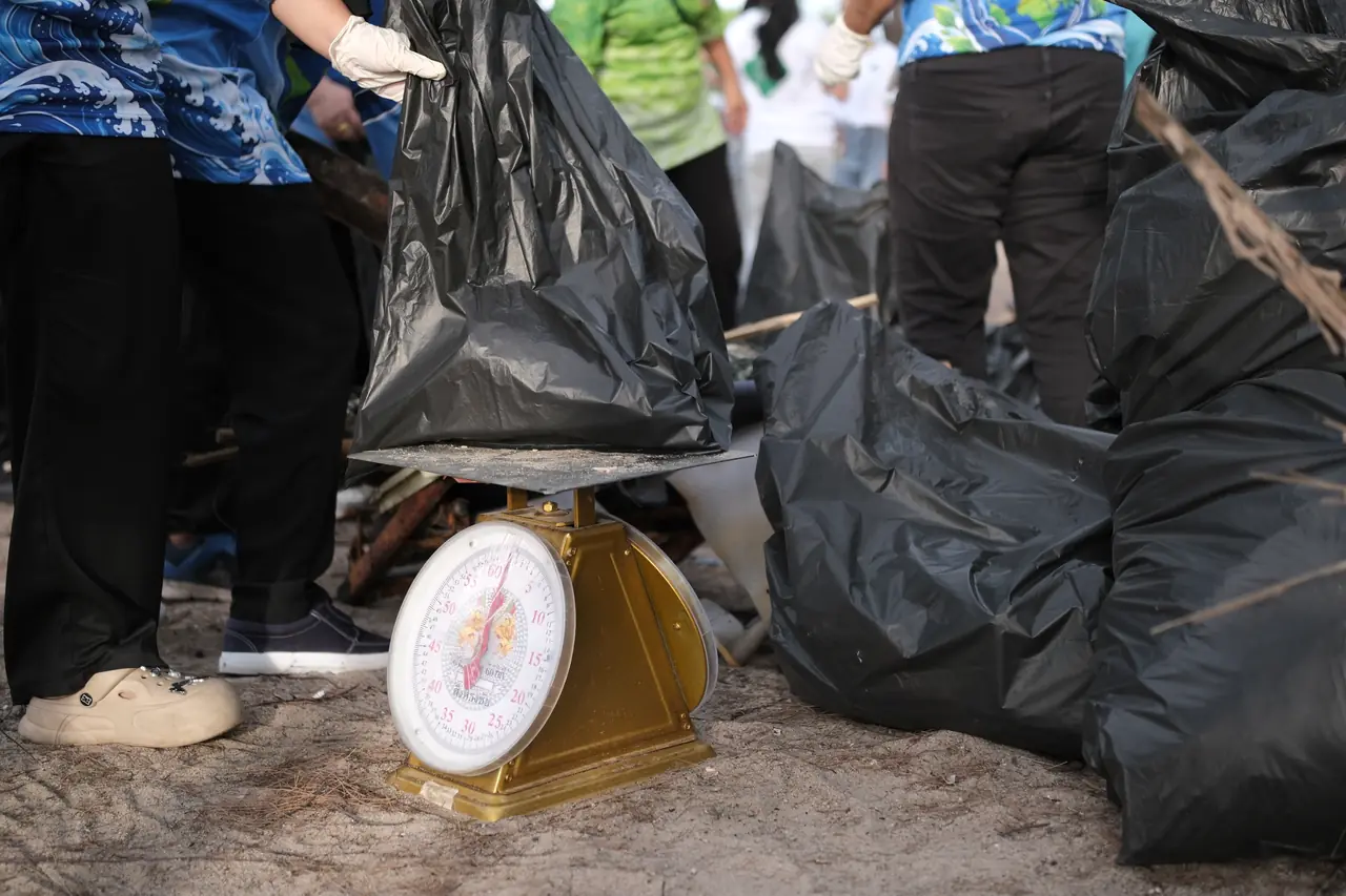 Full rubbish bags beside a weighing scale at the end of the clean-up
