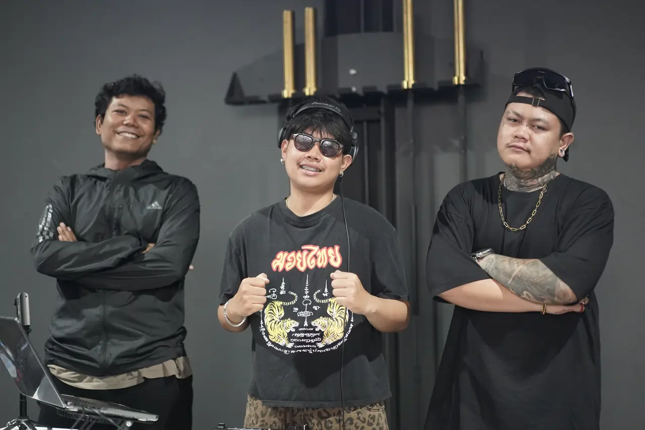 The DJ at his decks with two members of the crew beside him