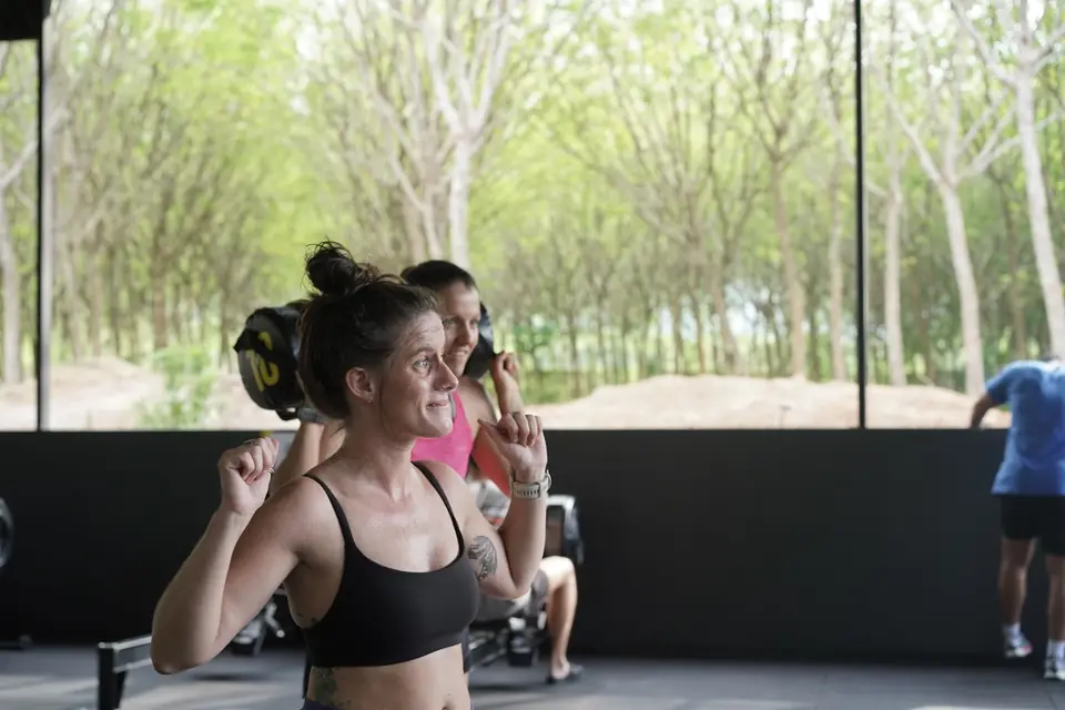 A woman flexes for the camera on the gym floor