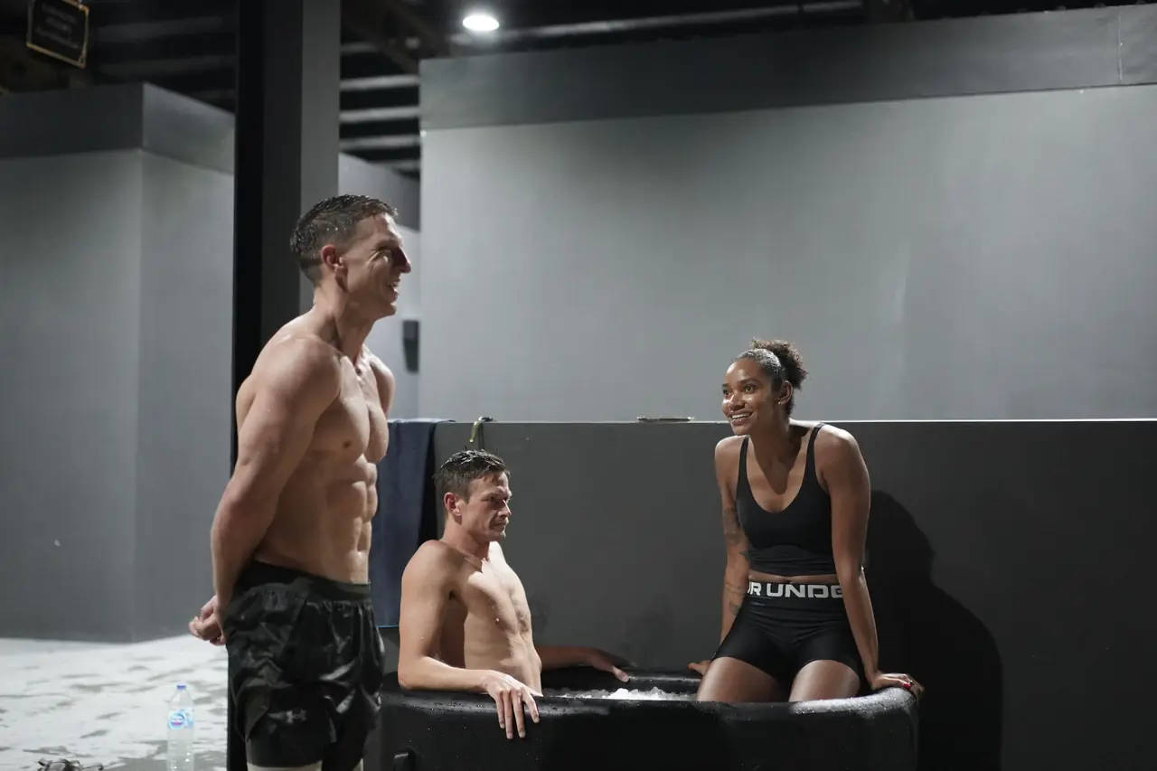 Three athletes cool down in the ice bath after their heat