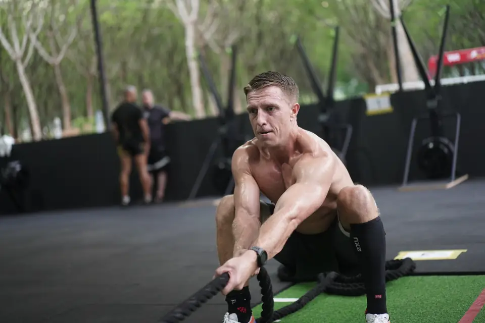 A man hauls the sled-pull rope on the turf