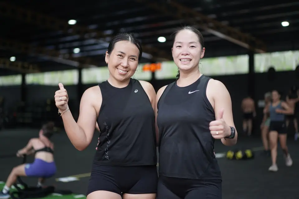 Two women give thumbs up after their heat