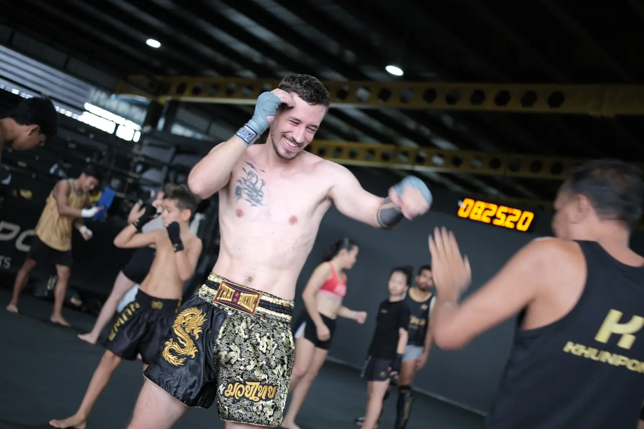 Students shadowbox during the warm-up of a Muay Thai class at Khunpon