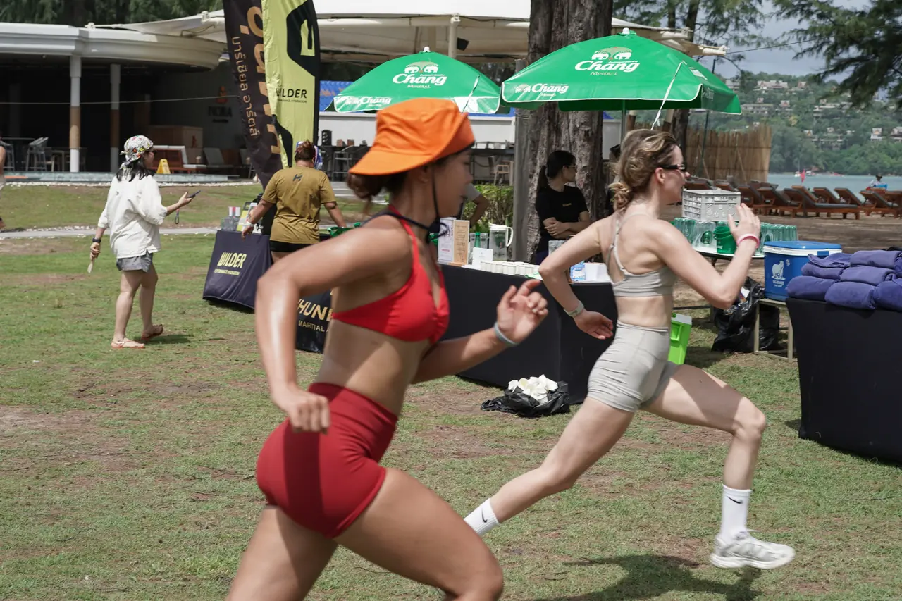 Two competitors sprint past the partner tents during the beach relay