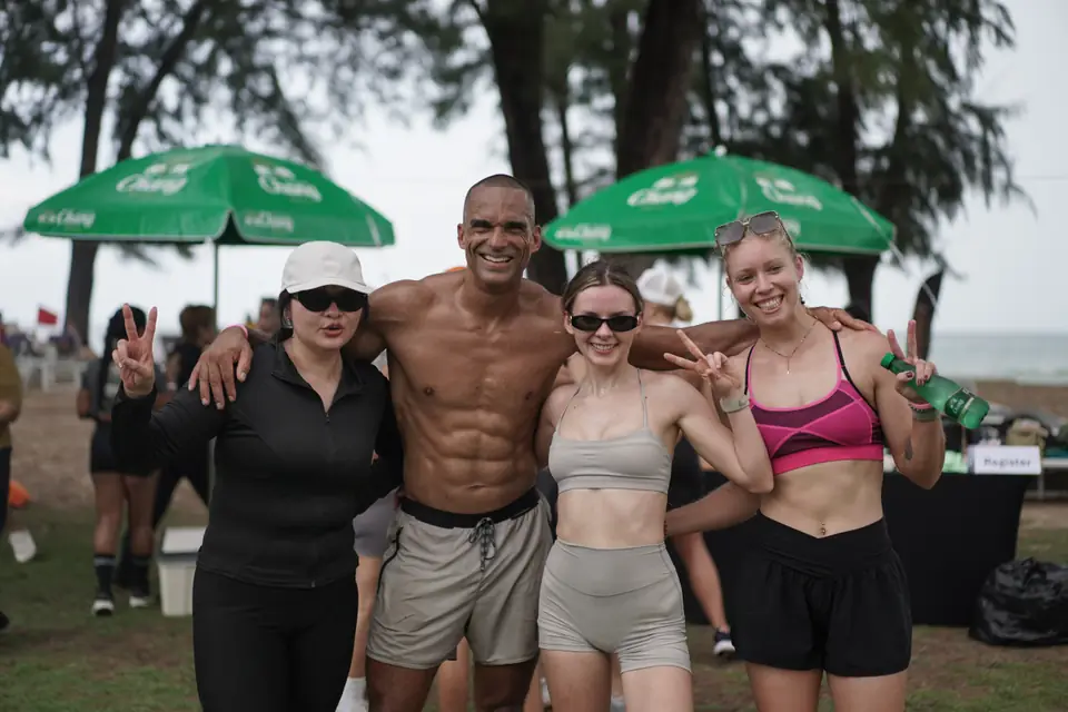 Four competitors give peace signs under the Chang umbrellas