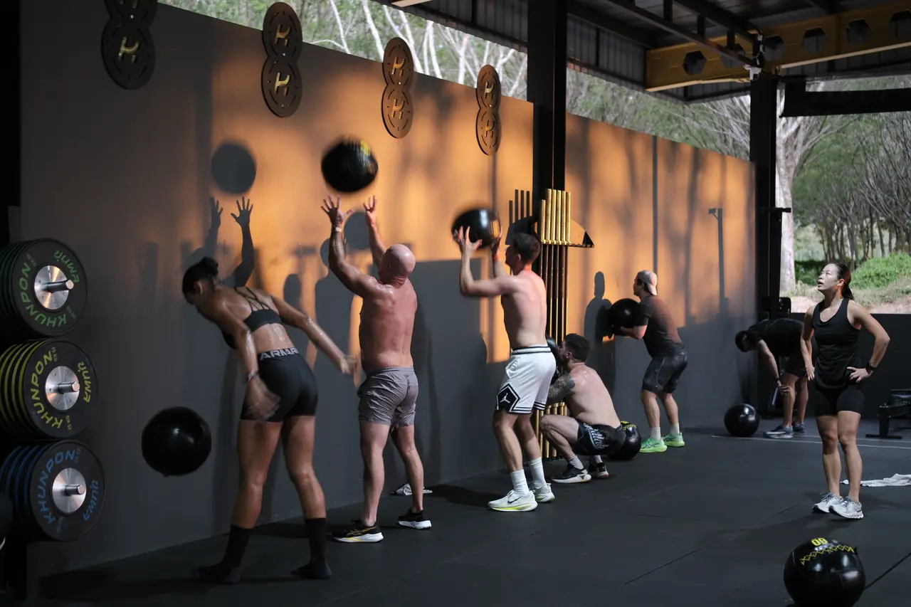 A HYROX class throws wall balls at the targets along the Khunpon wall