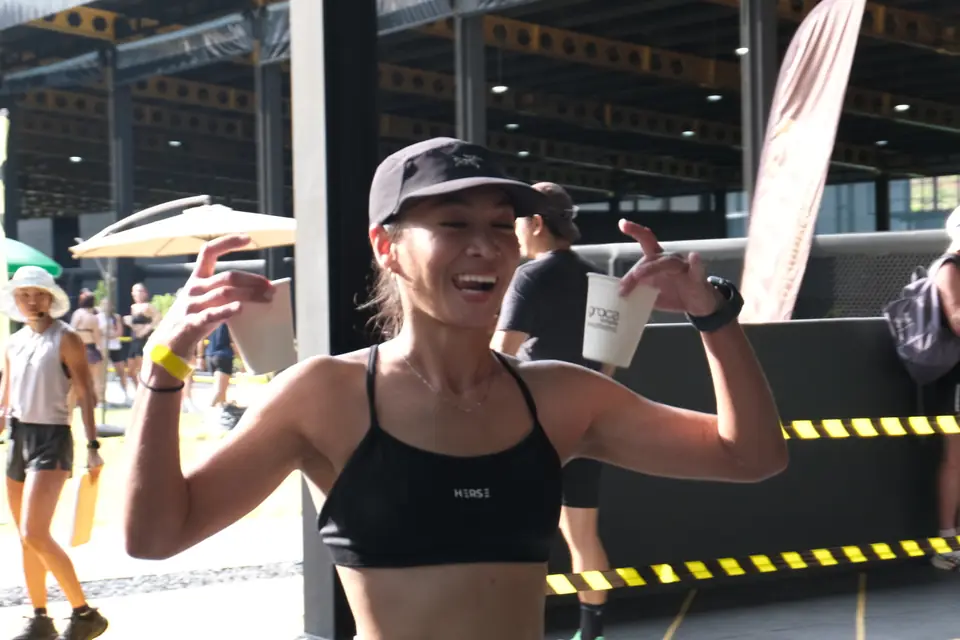 A competitor celebrates with both fists up beside the tape
