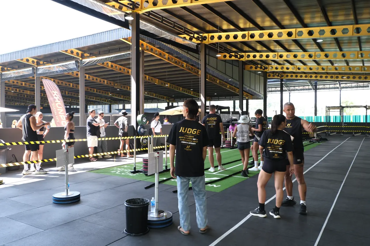 The simulation course at Khunpon, with judges in black JUDGE shirts standing by the sled lanes under the roof