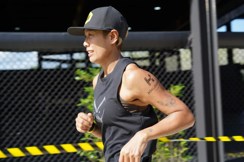 A runner in a Khunpon vest passes the fence on the run loop