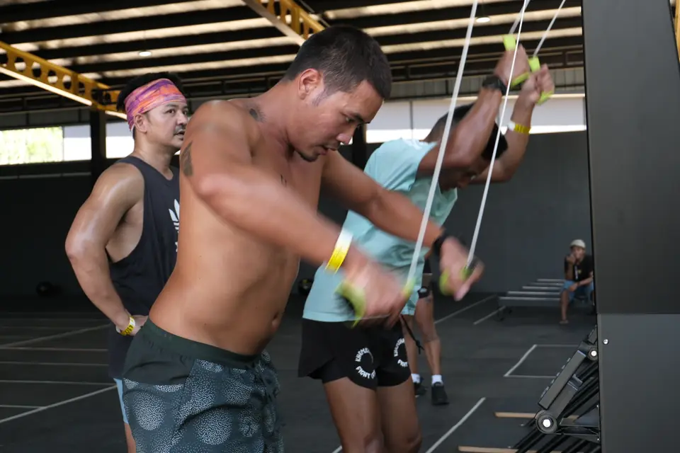 Three competitors work side by side on the SkiErgs at the first station