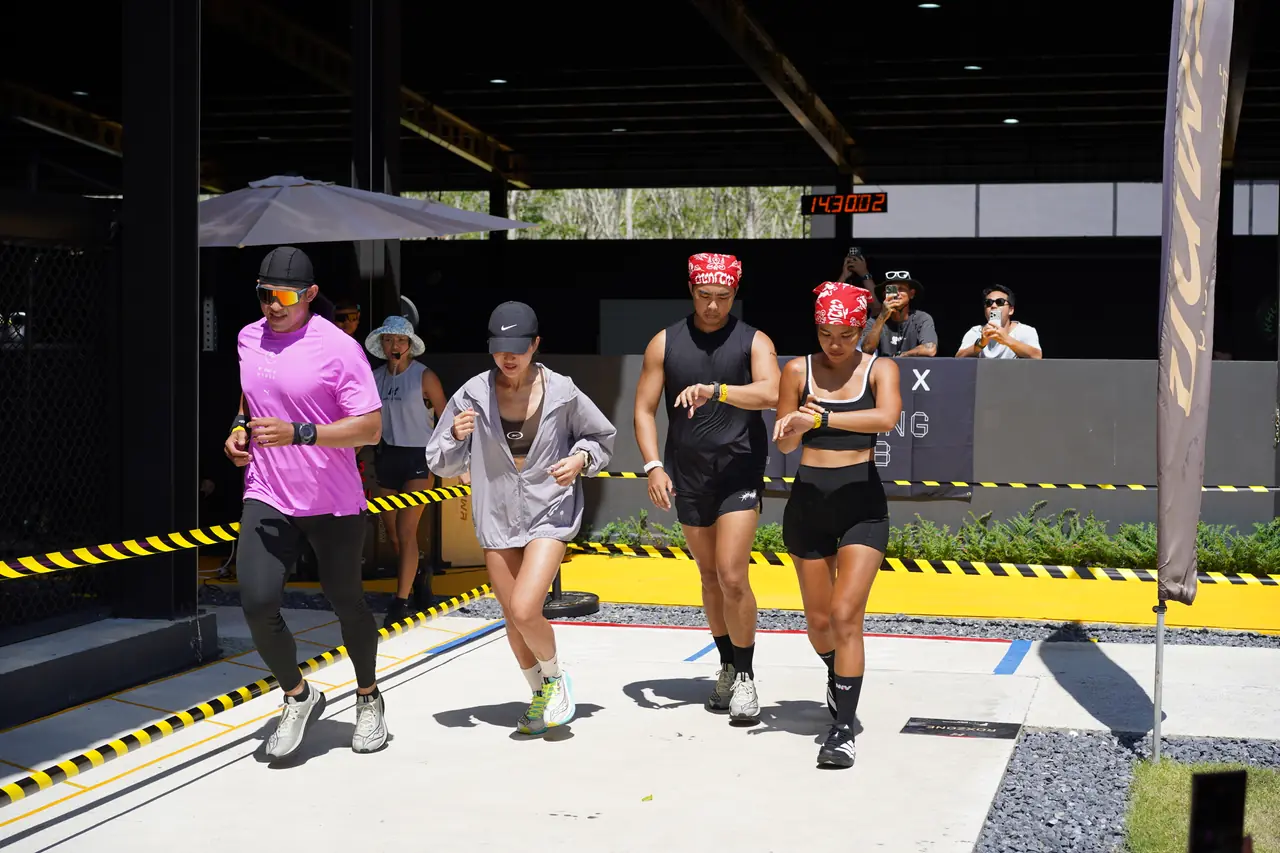 Four athletes set off together from the start line, one with both arms in the air