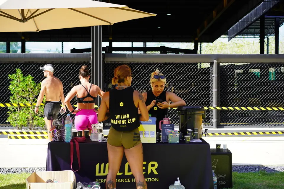 Two women stand ready at the WILDER hydration table