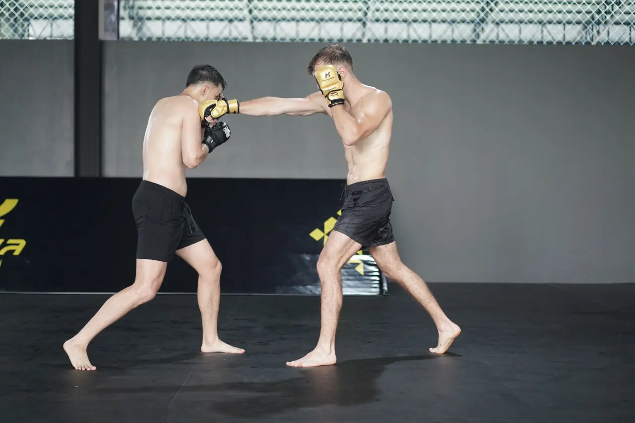 Two fighters trade punches in a boxing drill on the Khunpon mats