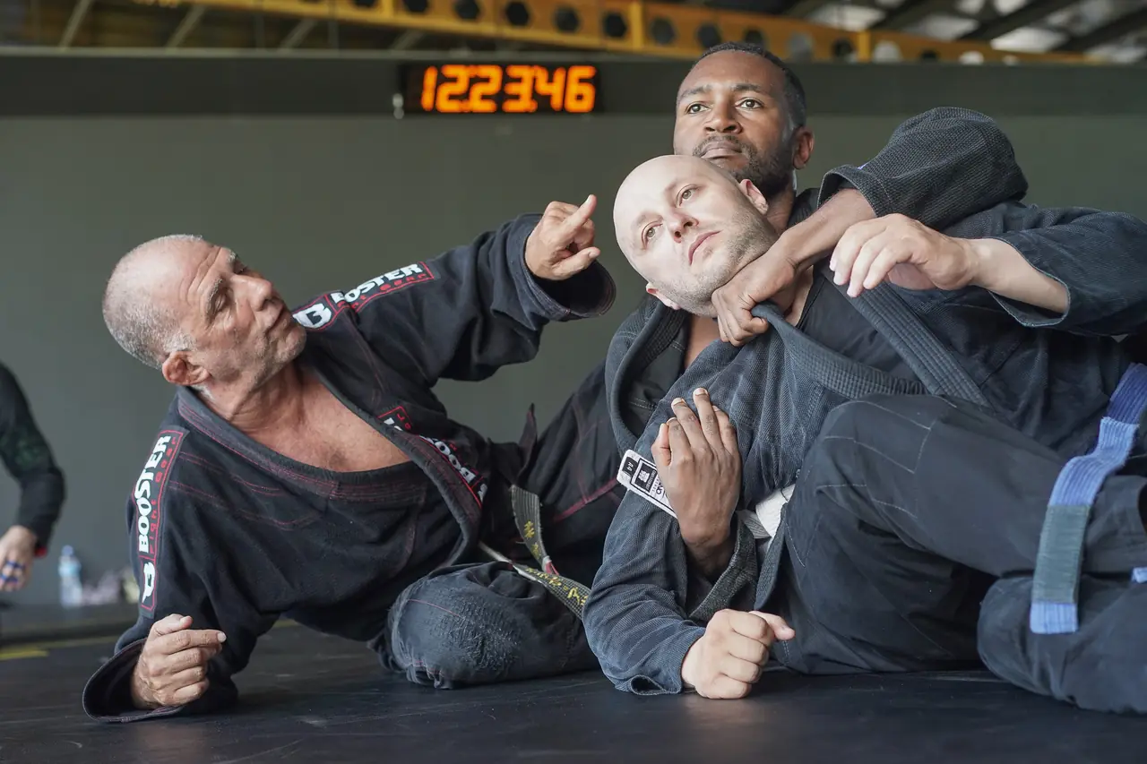 The Professor shows a grip on a student's collar while a second student watches from close range