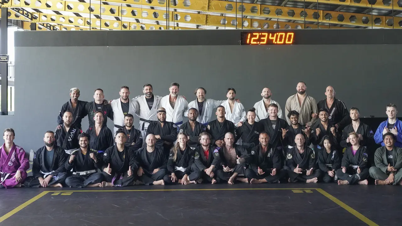 Everyone who attended the seminar, seated in rows on the mats with the Professor