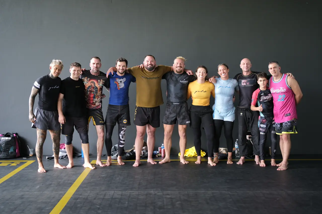Everyone who trained, arm in arm in a line across the mat with Sloan