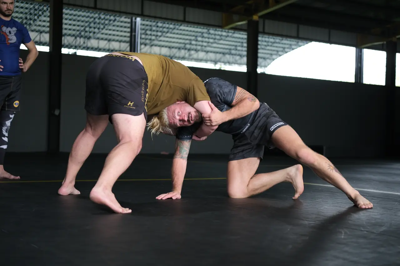 Two participants drill a body-lock takedown from the knees