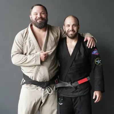 Coach Justin with a Brazilian Jiu-Jitsu student, both in the gi