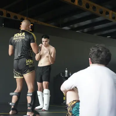Head Coach Mick demonstrates a stance beside a student