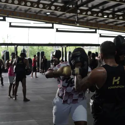 Pad work with the trainers in a busy Muay Thai class