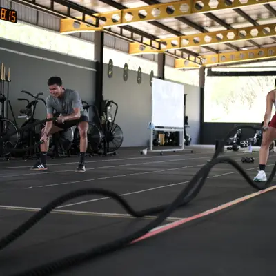 A member works the battle ropes in a circuit class