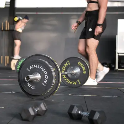 Weight plates, a kettlebell and dumbbells on the floor before a class