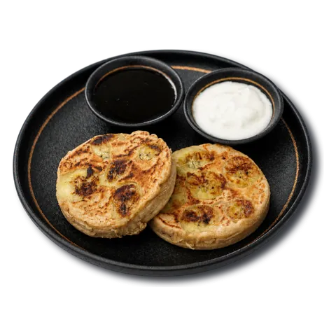 Two oat pancakes with honey and yoghurt on the side