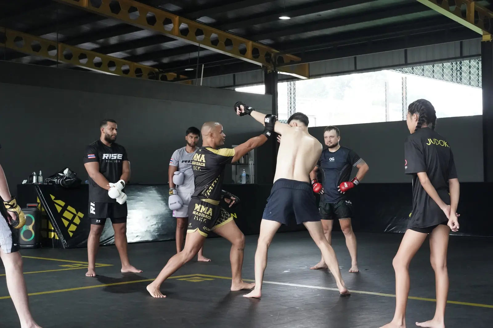 Head Coach Mick corrects a student's punch in a small MMA class
